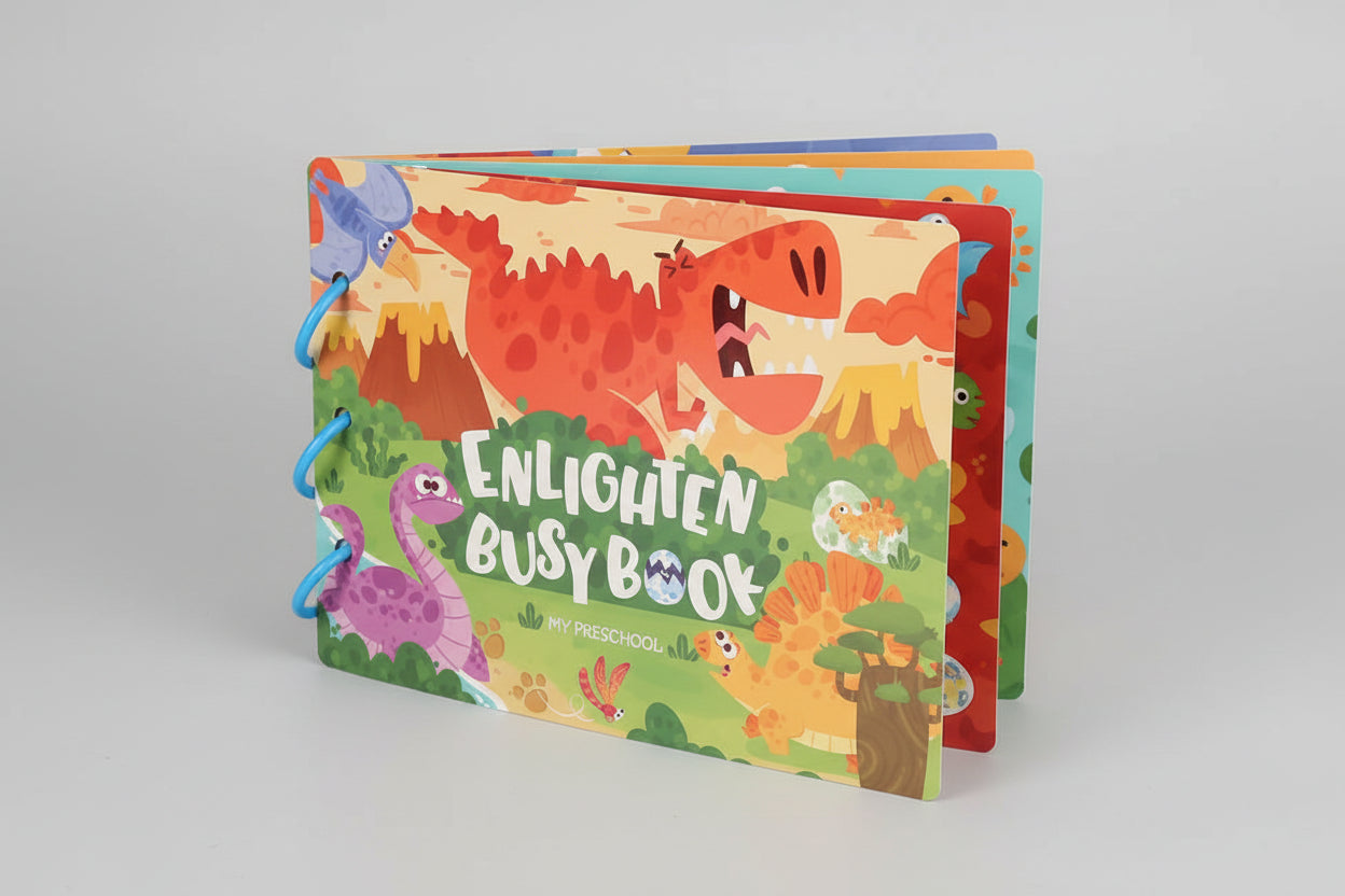 Colorful children's busy book with dinosaur illustrations on a wooden surface.
