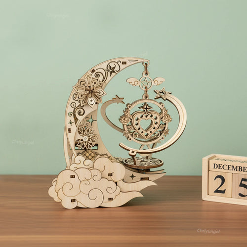 Wooden decorative item shaped like a crescent moon with intricate designs on a wooden surface.